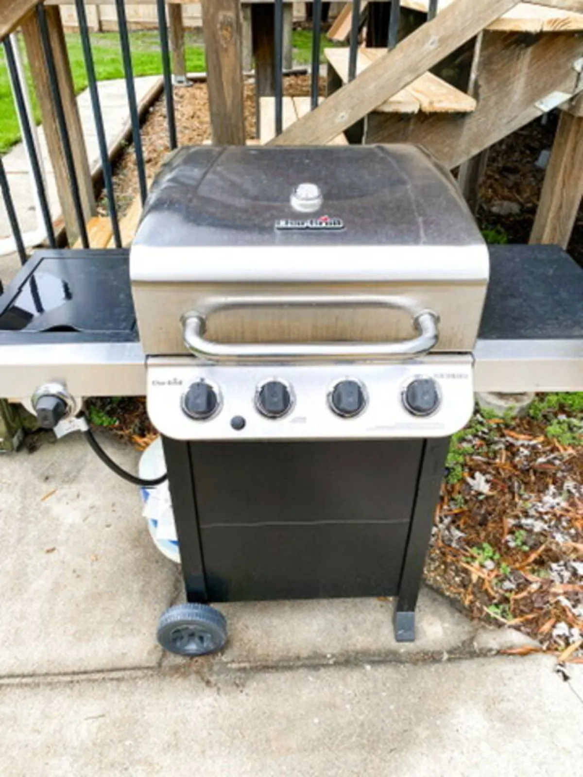 This exterior scene focuses on a gas grill set up for use, with hints of outdoor dining and friendly gatherings nearby. The mood suggests a casual, social atmosphere where guests can savor grilled meals together in the open air.