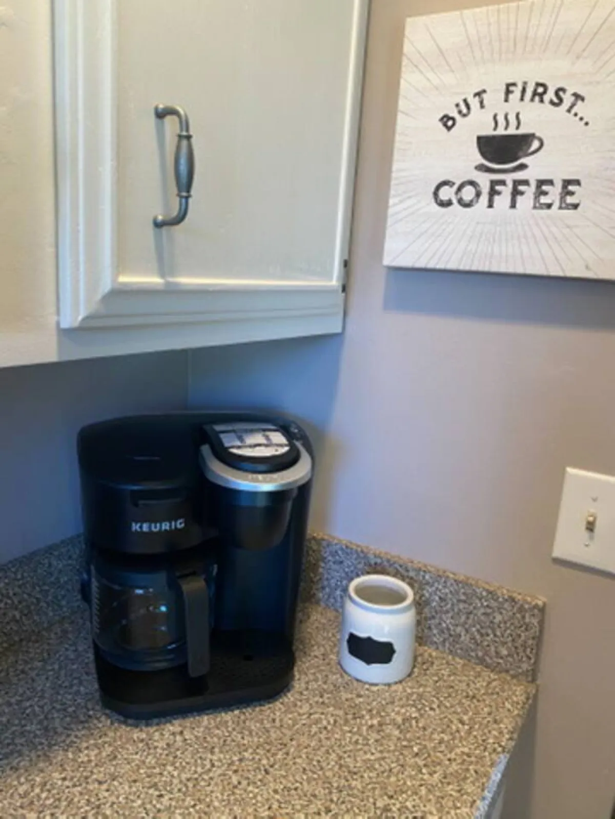 A welcoming coffee station featuring a coffee maker, motivational sign, and coffee containers. The area is set up for guests to gather in the morning, converse, and enjoy coffee together, creating a sense of communal routine and connection.